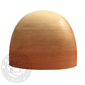 May include: A wooden hat block with a rounded, dome-like shape. The wood has a natural color gradient, transitioning from light tan at the top to a reddish-brown at the base. The image includes a watermark that reads "HAT BLOCKS AUSTRALIA".