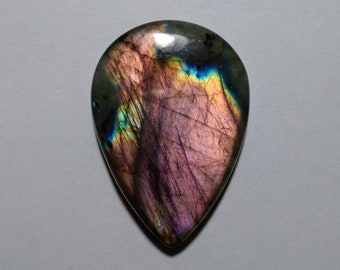 May include: A teardrop-shaped labradorite gemstone cabochon with iridescent blue, green, and purple hues. The stone has a smooth, polished surface and a natural, organic shape.