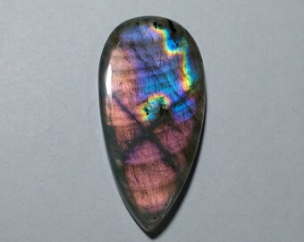 May include: A teardrop-shaped labradorite gemstone with iridescent blue, green, and purple hues.