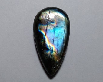 May include: A teardrop-shaped iridescent labradorite gemstone with a dark blue, black, and gold color.