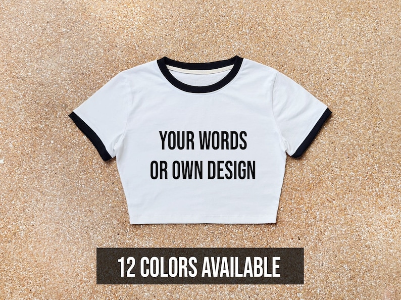 May include: White crop top with black trim and the text "YOUR WORDS OR OWN DESIGN". 12 COLORS AVAILABLE.