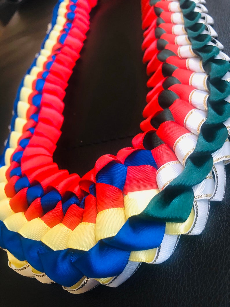 以下が含まれることがあります： サテンリボンでできた、マルチカラーのレイ。レイは、赤、青、黄、白、緑のリボンで作られています。リボンは、重ねて編まれています。