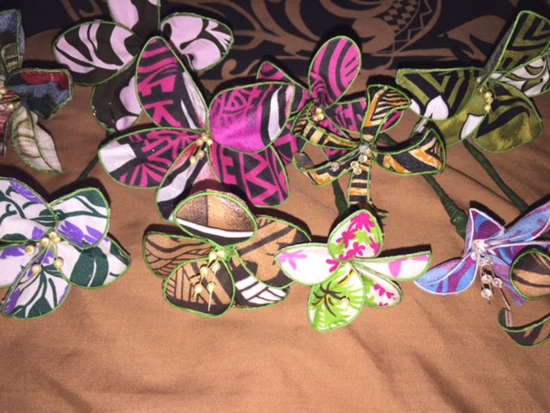 Puede incluir: Una colecci&oacute;n de ocho flores de tela hechas a mano con tallos verdes y varios patrones coloridos. Las flores est&aacute;n hechas de diferentes telas y tienen una variedad de dise&ntilde;os, que incluyen patrones florales, geom&eacute;tricos y abstractos.