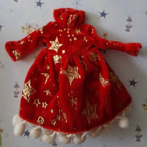 Puede incluir: Vestido de mu&ntilde;eca de terciopelo rojo con patrones de estrellas y puntos dorados. El vestido tiene mangas largas, cuello alto y falda con ribete de pomp&oacute;n blanco. El vestido mide aproximadamente 25 cm de largo.