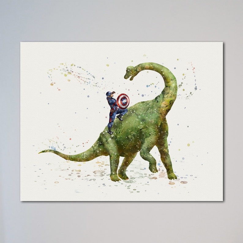 Op de afbeelding: Een aquarel schilderij van een groene dinosaurus met een superheld op zijn rug. De superheld draagt een rood, wit en blauw kostuum en houdt een schild vast. De achtergrond is lichtblauw met witte spetters.
