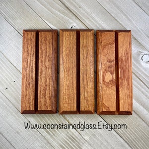 Op de afbeelding: Drie rechthoekige houten displaystandaards met een verticale groef. De standaards zijn gemaakt van roodbruin hout met zichtbare nerf. Het websiteadres "www.coonstainedglass.etsy.com" staat onderaan afgedrukt.