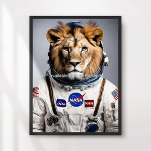 Könnte beinhalten: Gerahmter Druck eines Löwen in einem NASA-Astronautenanzug. Der Löwe hat eine braune Mähne und blickt nach vorne. Der Anzug zeigt das NASA-Logo und amerikanische Flaggenaufnäher. Der Druck ist in einem schwarzen Rahmen.
