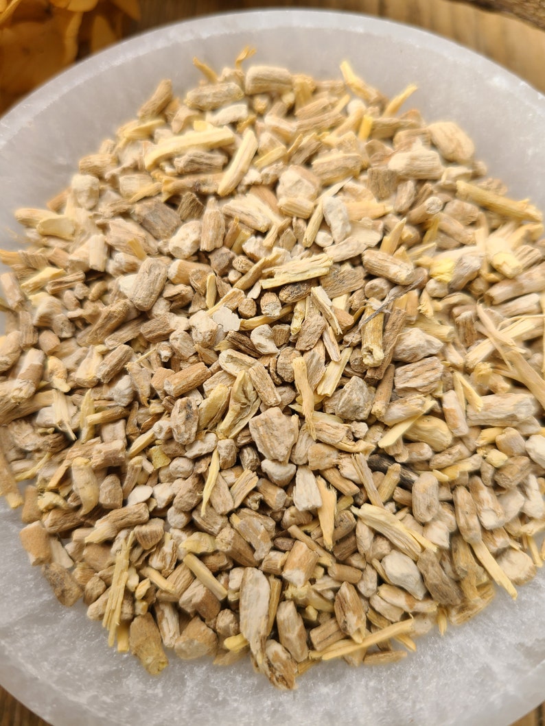 May include: A close-up view of a bowl filled with dried, light brown, and beige root pieces. The root pieces are irregularly shaped and have a rough texture.