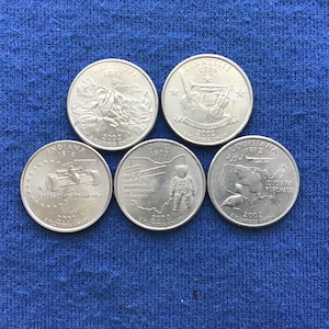 May include: Five United States quarter coins from 2002, featuring designs for Mississippi, Tennessee, Indiana, Ohio, and Louisiana. Each coin displays state-specific imagery and text, including the state name, year of statehood, and the year 2002.