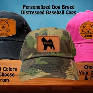 May include: Three distressed baseball caps with personalized dog breed patches. The caps are black, camouflage, and pink. The patches feature a dog silhouette with the names Lucy, Watson, and Jack.