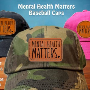 May include: Baseball caps in black, camouflage, and pink, each featuring a leather patch with the text "MENTAL HEALTH MATTERS." The image also includes the text "8 Hat Colors To Choose From."