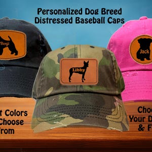 May include: Three distressed baseball caps with personalized dog breed patches. The caps are black, camouflage, and pink. The patches feature a silhouette of a dog with the names Benji, Libby, and Jack.