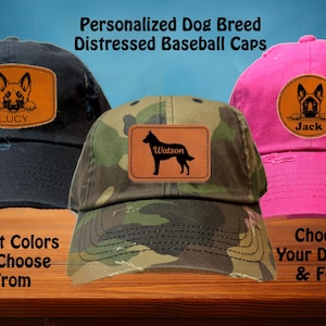 May include: Three distressed baseball caps with personalized dog breed patches. The caps are black, camouflage, and pink. The patches feature a German Shepherd, a Labrador Retriever, and a Jack Russell Terrier. The text on the patches reads "Lucy", "Watson", and "Jack".