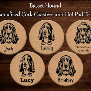 Puede incluir: Cinco posavasos redondos de corcho con ilustraciones de Basset Hound en negro. Cada posavasos tiene un nombre diferente: Jack, Libby, Lucy, Brinkley, y uno con un gorro de Papá Noel y el texto "Schoonveld Kennels". El texto "Basset Hound" y "Personalized Cork Coasters and Hot Pad Trivets" están en la parte superior.