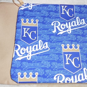 May include: Blue and white fabric seat cushion with a repeating pattern of the Kansas City Royals logo and the words "Kansas City Royals".
