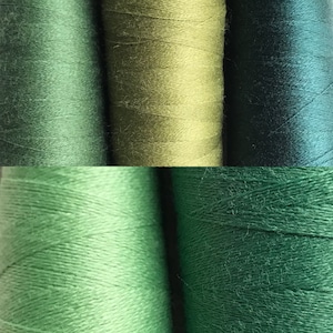 May include: A close-up shot of several green thread spools. The colours vary from light, spring green to deep forest green, creating a gradient effect. The thread is tightly wound, indicating a high-quality material suitable for sewing or crafting.
