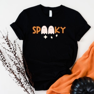 May include: Black t-shirt with a graphic of three ghosts and the word "SPOOKY" in orange and white.