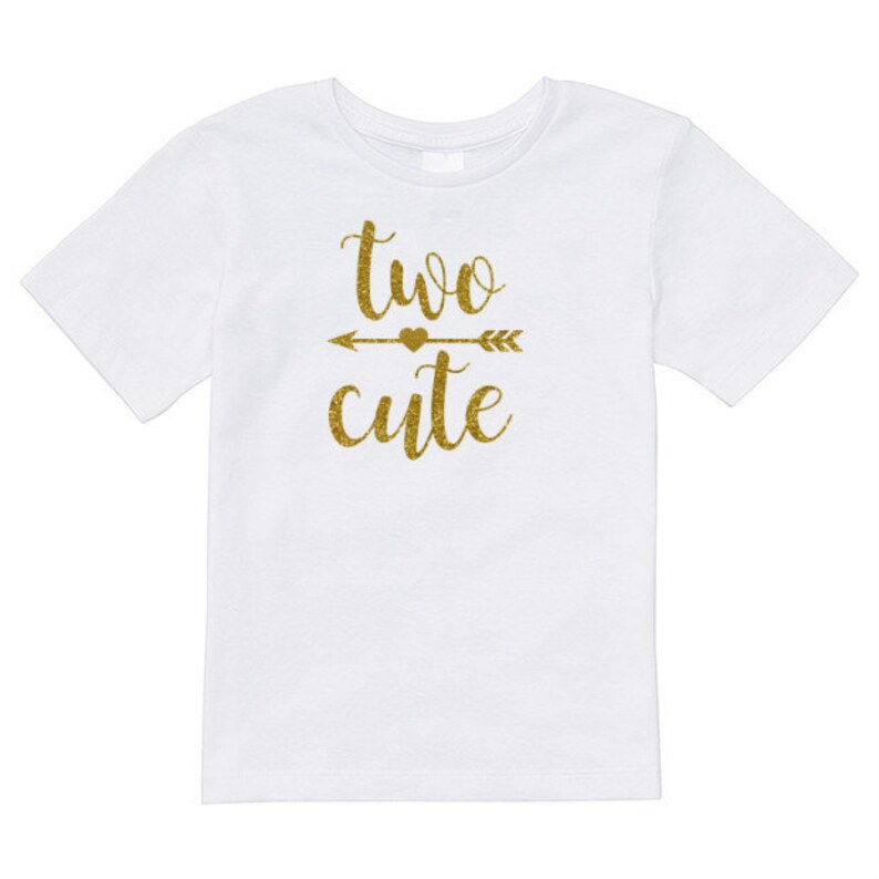 May include: White t-shirt with gold glitter lettering that says "two cute" with an arrow and heart in between the words.