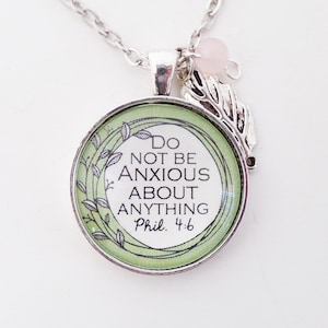 May include: Silver necklace with a green round pendant that says "Do not be anxious about anything Phil. 4:6" with a silver leaf charm and a pink bead.