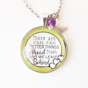 May include: A silver necklace with a green round pendant that says "There are far, far better things ahead than any we leave behind." The pendant has two white hearts on the bottom. The necklace also has a purple bead and a silver star charm.