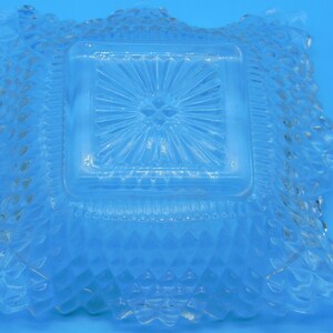 Puede incluir: Un plato cuadrado de vidrio transparente con un patr&oacute;n de diamante elevado alrededor del borde y un patr&oacute;n de estrella en el centro.