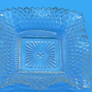Puede incluir: Un plato cuadrado de vidrio transparente con un patr&oacute;n elevado en forma de diamante alrededor del borde y un cuadrado m&aacute;s peque&ntilde;o en el centro con un patr&oacute;n de estrella.