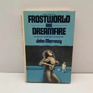 May include: A blue and white paperback book cover with the title "Frostworld and Dreamfire" by John Morressy. The cover features a black and white illustration of a humanoid creature with long hair and a person walking in the distance.