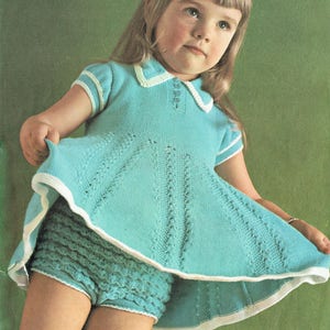 Puede incluir: Un conjunto vintage de vestido y pantalón corto a juego de color turquesa tejido. El vestido presenta un cuello y ribete blancos, con una falda acampanada. El pantalón corto tiene un borde con volantes. El texto de la imagen dice "Para pecho 53-56 cm".