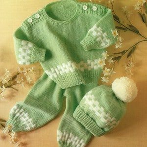 Puede incluir: Un conjunto de punto para bebé de color verde y blanco, compuesto por un jersey y un gorro. El jersey tiene cuello redondo y mangas largas. El gorro tiene un pompón blanco en la parte superior. El patrón es un punto doble con rayas blancas. Tallas 46-61 cm.