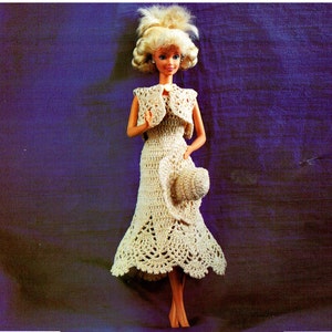 May include: A crocheted dress and matching hat for a doll. The dress is white with a lacy design and the hat is a wide-brimmed sun hat.