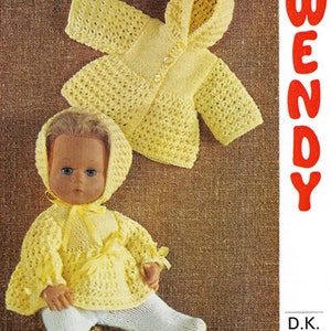 Può includere: Un completo in maglia gialla per bambola con cappuccio, con chiusura a bottone e fiocco. Il completo è mostrato su una bambola con occhi azzurri e capelli biondi. Il numero del modello 1757 e il marchio Wendy sono stampati sull'immagine.