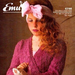 May include: A pink knitted cardigan with a double knit pattern. The cardigan has a V-neck and is worn by a young person with long, curly red hair. The person is wearing a pink headband with a bow. The image includes the text "6798 DOUBLE KNITTING 61-86 cm 24-34 in. Six sizes."