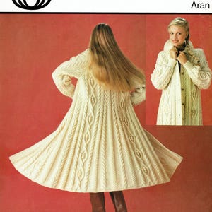 May include: A white knitted cardigan with a cable knit pattern. The cardigan is shown in two views, one from the front and one from the back. The cardigan is long and has a collar. The pattern number is 6152 and the size is 34-38 inches. The cardigan is featured in Woman's Realm.