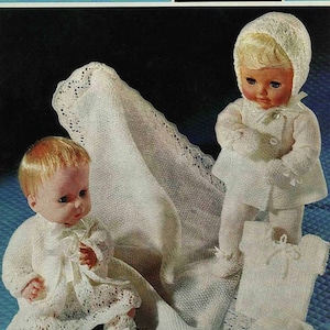 Può includere: Modello di maglieria vintage con due bambole vestite con completi in maglia bianchi, tra cui cappotti, cappellini e stivaletti. È inclusa anche una coperta in maglia bianca. Il modello è per due taglie per bambole da 35,5 cm e 40,6 cm. Il testo "SIRDAR" è visibile.