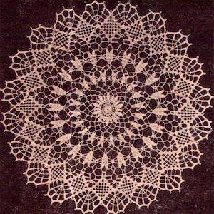 May include: Cream-colored, circular doily with an intricate, openwork design. The doily features a central floral motif surrounded by geometric and floral patterns. The edges are scalloped, adding a delicate touch. The doily is set against a dark background.