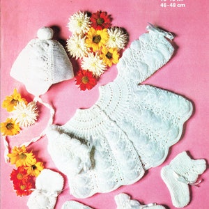 May include: White knitted baby outfit with a hat, cardigan, and booties. The outfit is made with Courtelle nylon yarn and is for a baby 18-19 inches (46-48 cm).