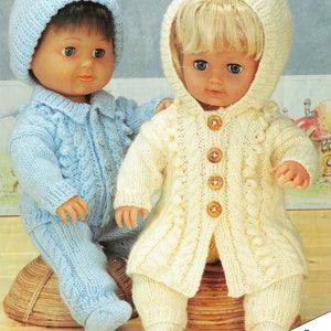 May include: Two knitted doll outfits, one in blue and one in cream, with matching hats. The outfits feature a cable knit pattern and button closures. The text "FOR DOLLS AND PREMATURE BABIES" is visible at the bottom of the image.