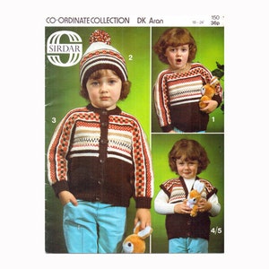 May include: A knitting pattern booklet for a child's sweater and hat. The pattern is called "Co-ordinate Collection DK Aran" and is from the brand "Sirdar". The booklet shows a child wearing a brown sweater with a colorful stripe pattern and a white hat with a brown brim.