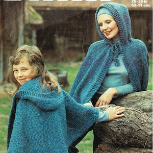 Könnte beinhalten: Zwei Personen tragen blaue gestrickte Pullover mit Kapuze. Der Pullover ist ein grobmaschiger Strick mit einem strukturierten Muster. Die Pullover werden mit einer blauen Jeans getragen. Das Bild stammt aus einem Strickmusterbuch.