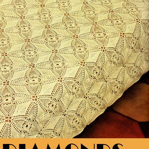 May include: A close-up of a crocheted bedspread with a diamond pattern. The bedspread is a light cream color and has a delicate, intricate design.