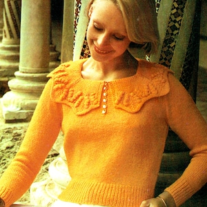 May include: A woman wearing a bright orange knitted sweater with a large, white, crocheted collar. The sweater has a button closure at the neckline.