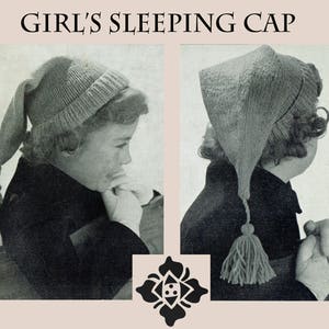 Puede incluir: Primer plano de una niña con una gorra de dormir de punto gris con borla. La gorra tiene una parte superior puntiaguda y una cola larga y fluida. La niña mira hacia un lado.