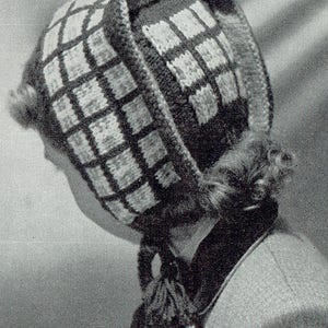 May include: A black and white knitted hat with a geometric pattern. The hat has a long tassel and a fold-down flap.