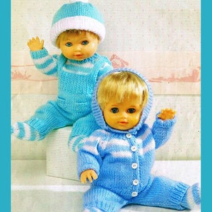 Könnte beinhalten: Zwei gestrickte Puppenoutfits in Blau und Weiß mit weißen Knöpfen. Die Outfits sind ein Kapuzenoverall und ein Hut- und Overall-Set.