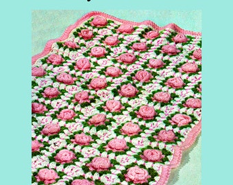May include: A crochet baby blanket with a "Rose-Garden" design. The blanket is made with pink and green yarn and features a repeating pattern of roses.