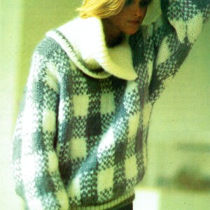 May include: A white and gray checkered sweater with a large white turtleneck collar. The sweater is made of a soft, fuzzy material.