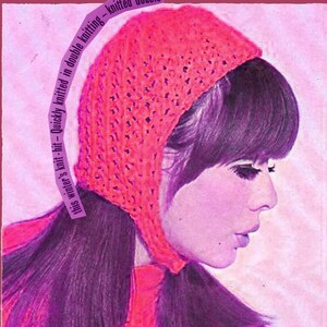 May include: A pink knitted hat with a lacy pattern. The hat is worn by a woman with long dark hair. The text "this winter's knit-hit - Quickly knitted in double knitting - knitted double" and "the Snuggle" are visible in the image.