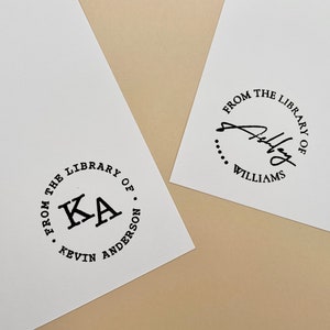 May include: Two white cards with black circular stamps. The first stamp says "From the Library of Kevin Anderson" with the initials "KA" in the center. The second stamp says "From the Library of Williams" with a handwritten signature.