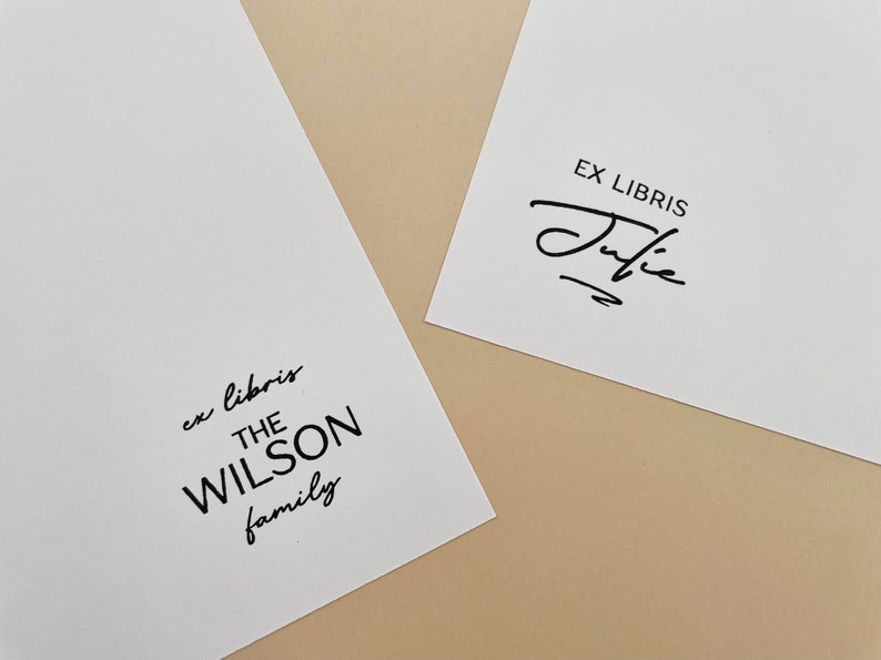 May include: Two white cards with black text. The top card says "Ex Libris" with a handwritten signature below. The bottom card says "ex libris THE WILSON family".