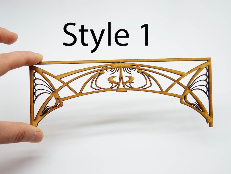 May include: A wooden archway with a decorative Art Nouveau design. The archway is made of laser-cut wood and is unfinished. The archway is labeled "Style 1".
